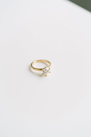 Round lab grown diamond solitaire engagement ring in prong setting, crafted in 14K gold for timeless and ethical elegance.