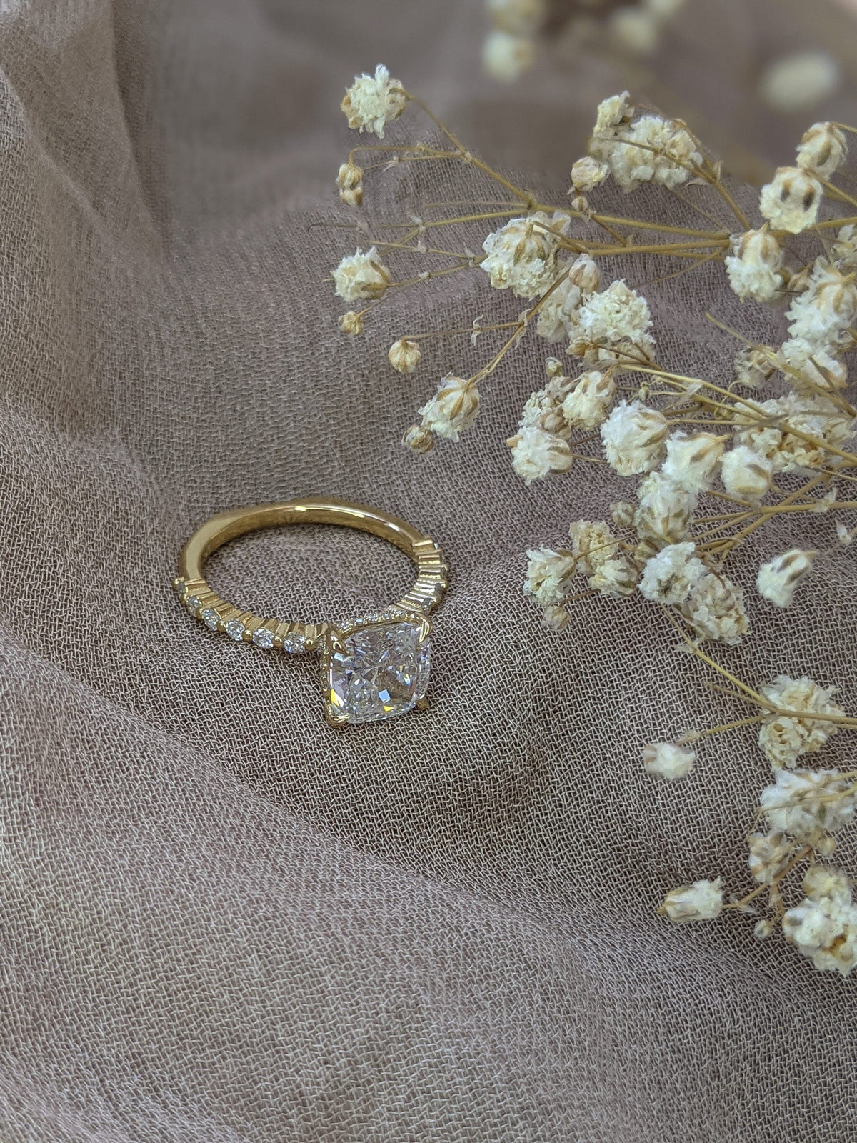Cushion cut lab grown diamond engagement ring with pave band in 14K gold, featuring soft corners and radiant sparkle.