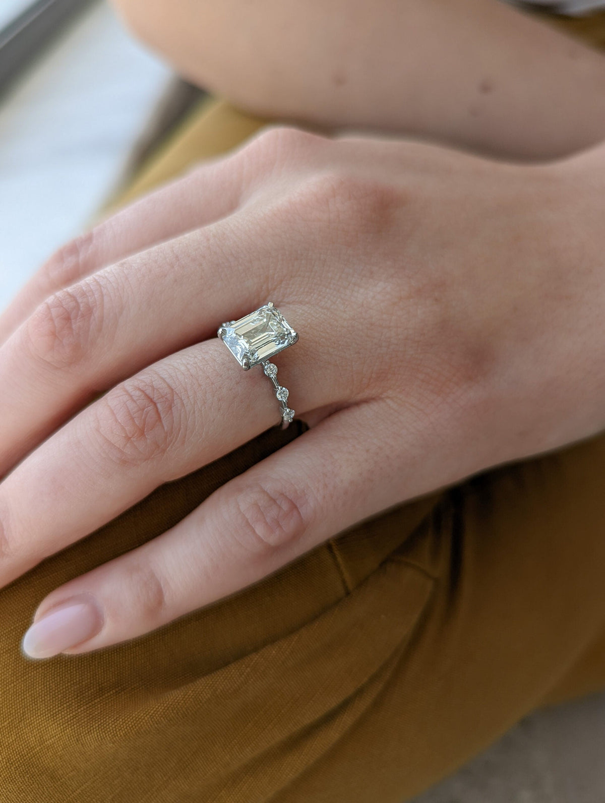 Emerald cut lab grown diamond dainty engagement ring in 14K gold with delicate setting, designed for subtle sparkle and elegance.
